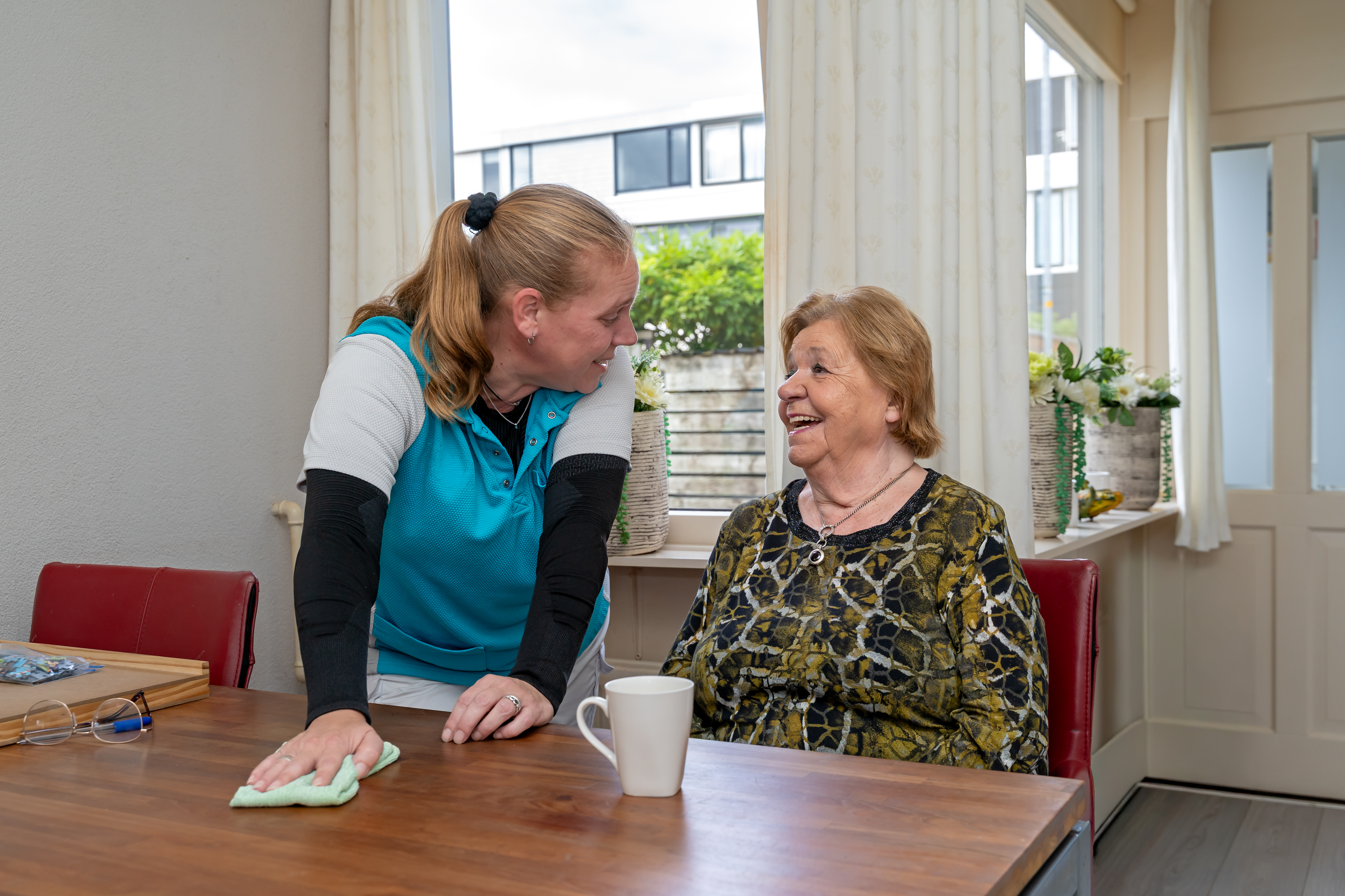 Twee vrouwen waarvan een schoonmaakt