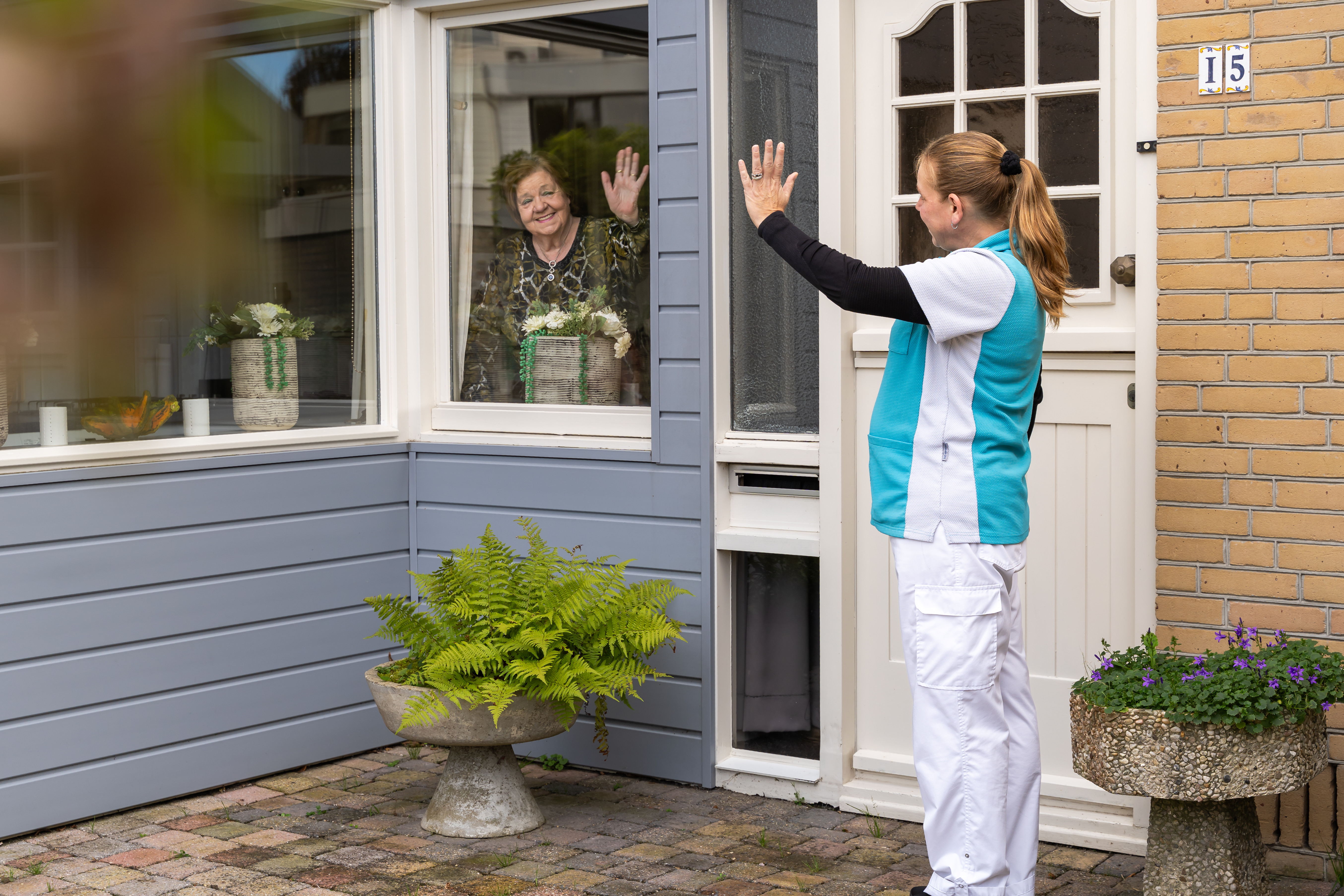 Twee vrouwen die naar elkaar zwaaien