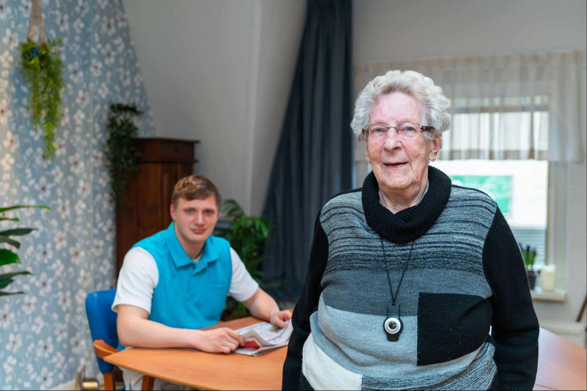 Man zit aan tafel en vrouw staat ervoor