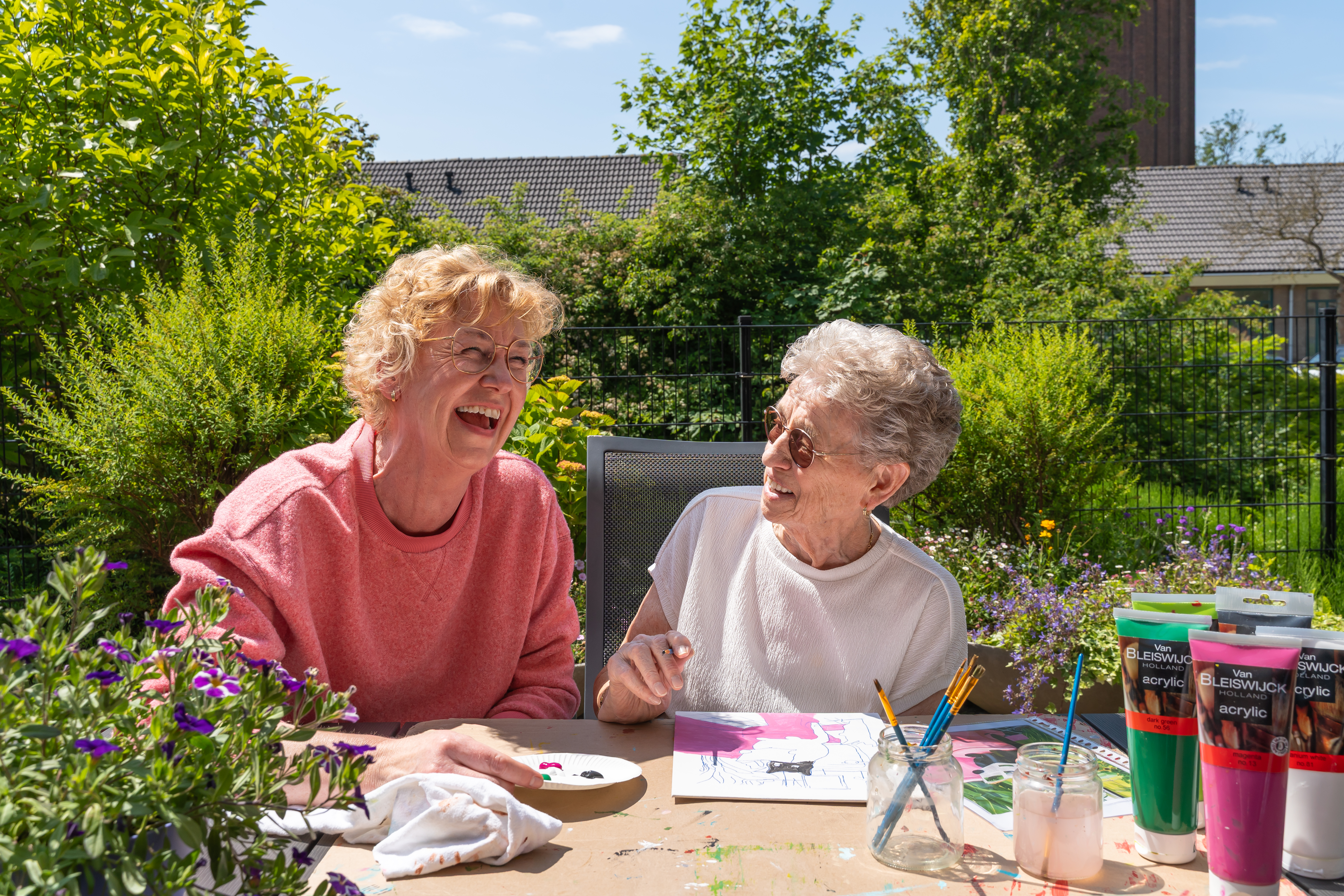 Zorgmedewerker en bewoners verzorgingshuis wandelen
